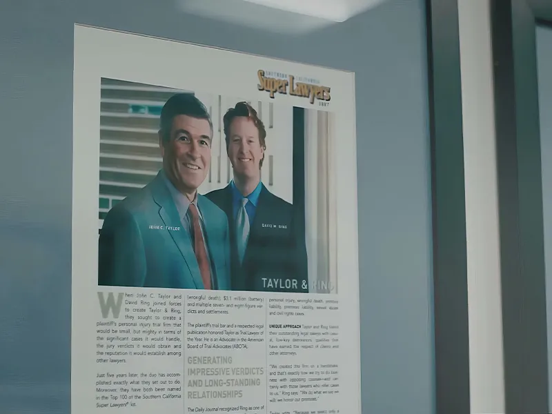 A framed Super Lawyers magazine feature on the founding partners of Taylor & Ring, displayed on the law firm's office wall