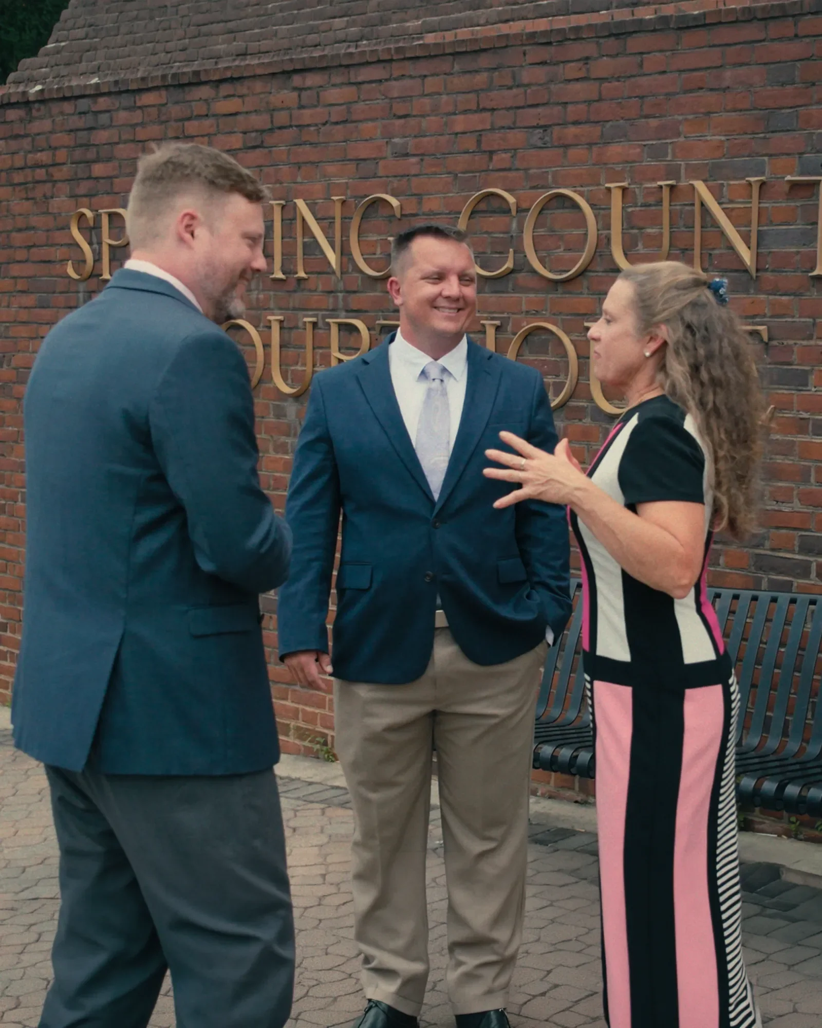 Law firm team speaking outside a courthouse during a brand video production shoot